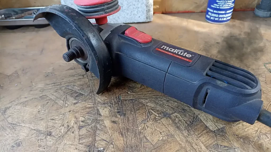 Amoladora angular soltando chispas internas por las ranuras de ventilación con técnico evaluando la falla.