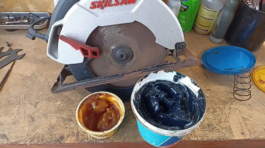 Un técnico aplicando grasa negra de molibdeno en los engranajes internos de un rotomartillo SDS Max desarmado.