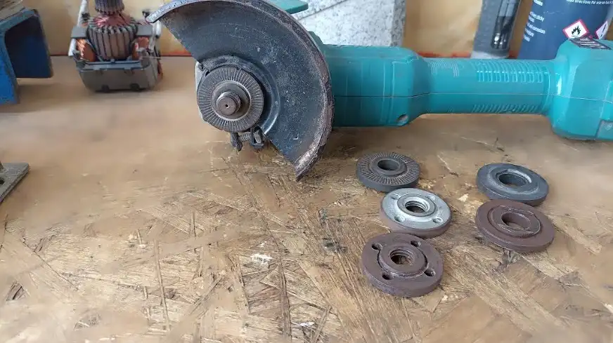 Primer plano de una tuerca de amoladora angular desgastada y un disco de corte mal colocado, enfoque en la seguridad.
