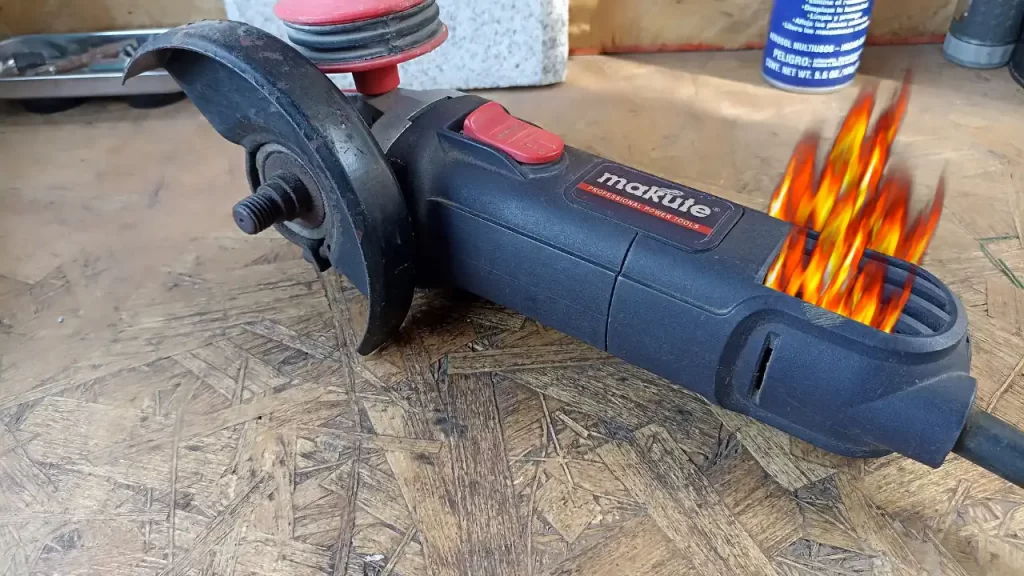 Imagen técnica de una amoladora con rejillas de ventilación obstruidas por polvo rojo, mostrando una mano con guante térmico revisando la temperatura del cabezal metálico.